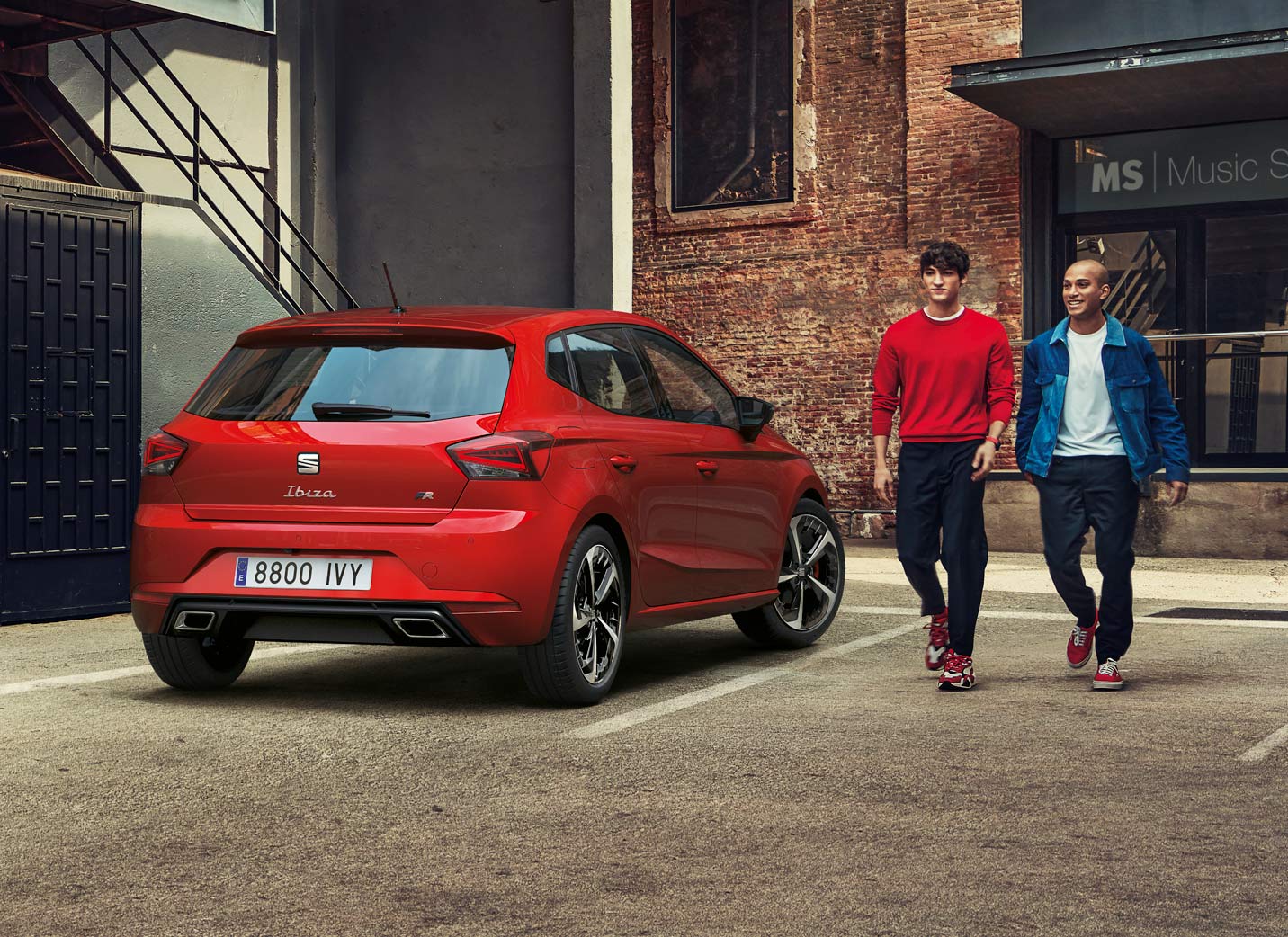 Dos hombres caminando delante de su SEAT Ibiza